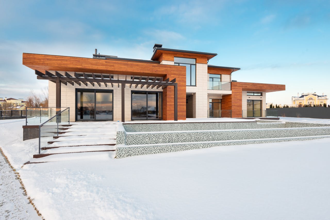 Exterior view of contemporary residential house with terrace and large windows located in suburban area in winter day